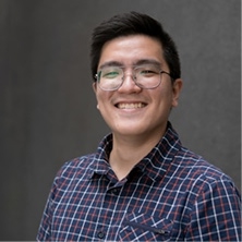 Portrait d'un jeune homme souriant à lunettes en chemise à carreaux